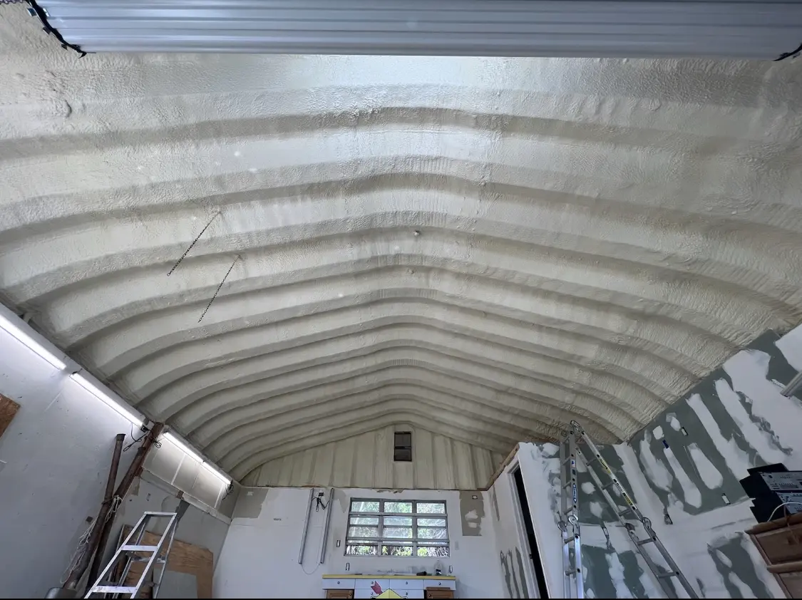 Spray polyurethane foam applied to the underside of a metal roof deck in Lemay
